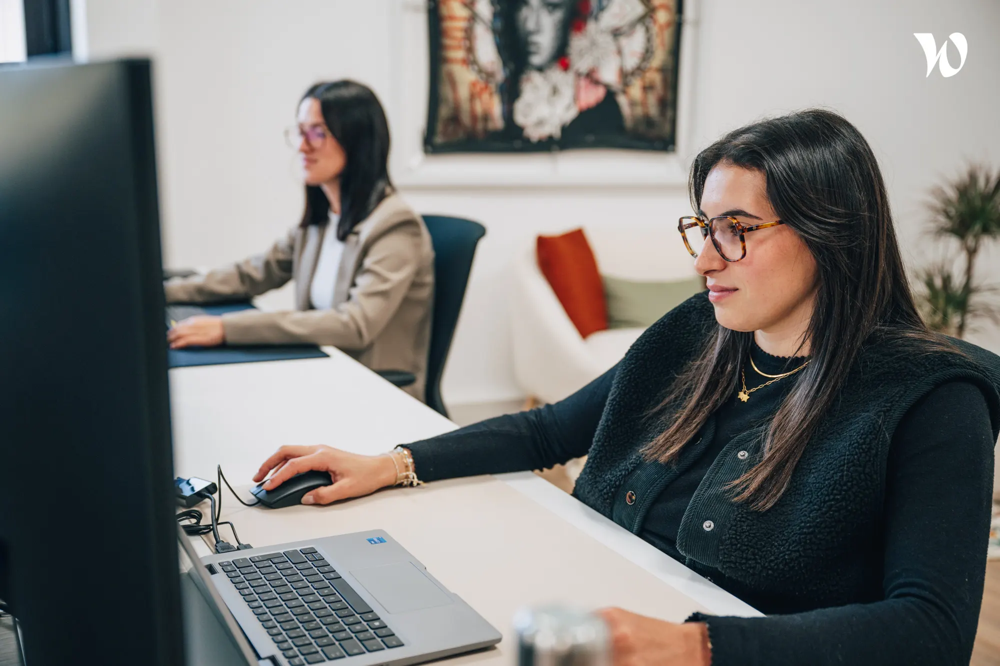 <p>jeune femme avec lunette qui regarde son ordinateur</p>
